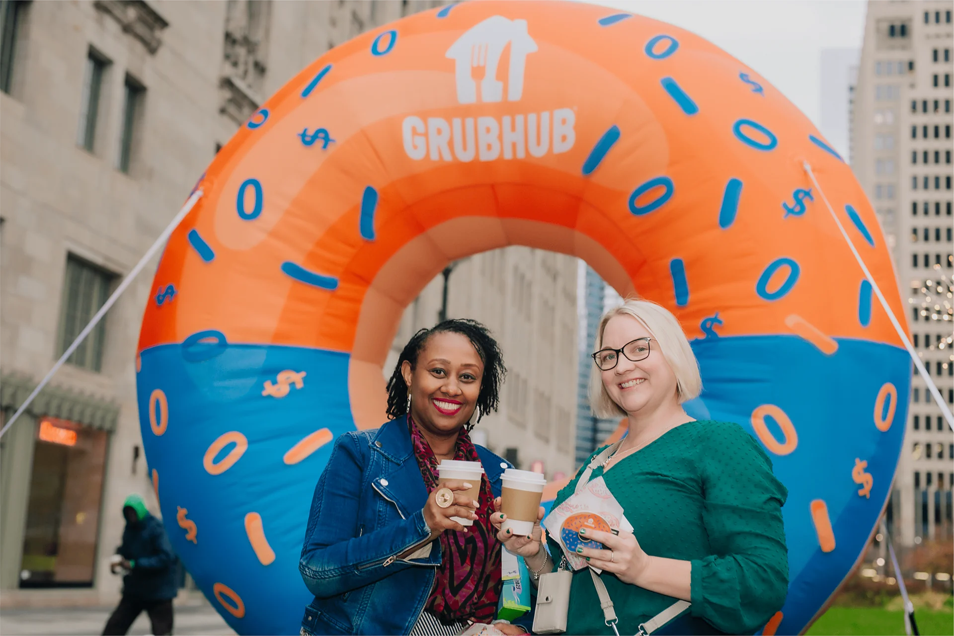 Guests posing with coffee inside the giant inflatable GrubHub donut