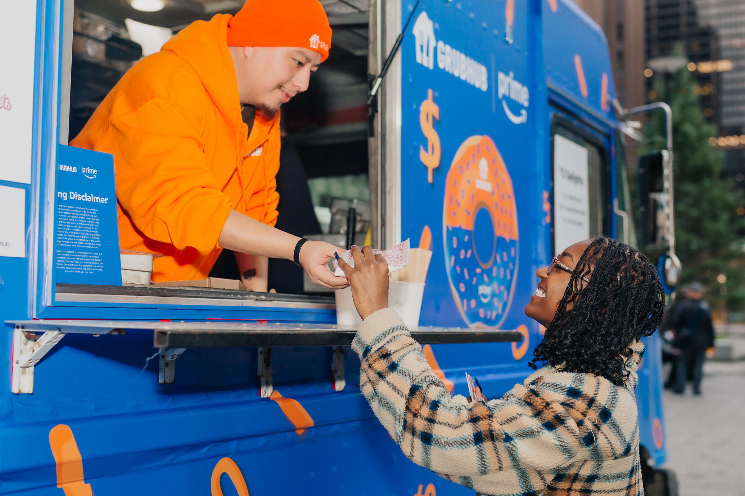 Brand Ambassador handing a treat to a smiling guest at the truck window