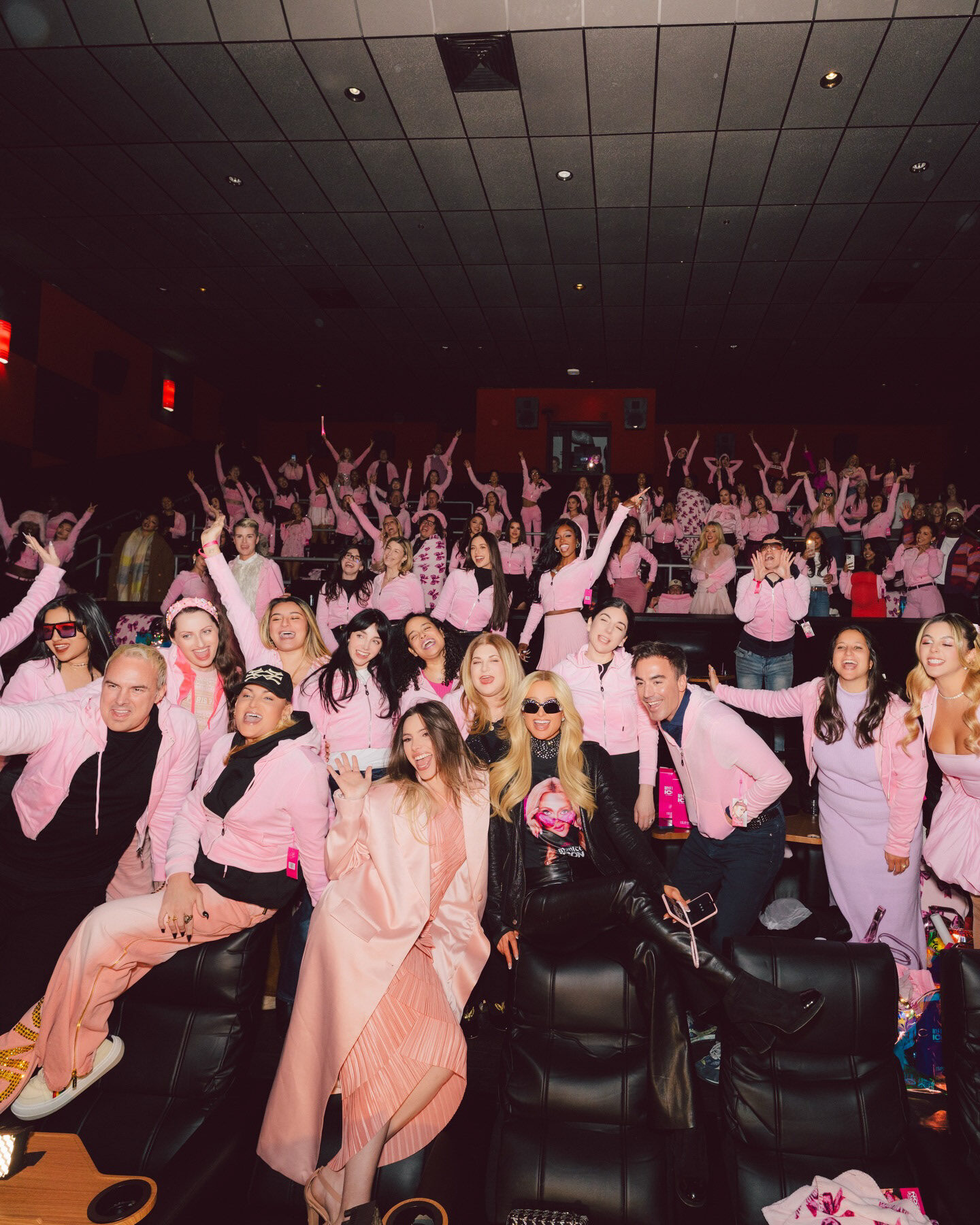 A theater full of guests in pink celebrating at the Infinite Icon premiere