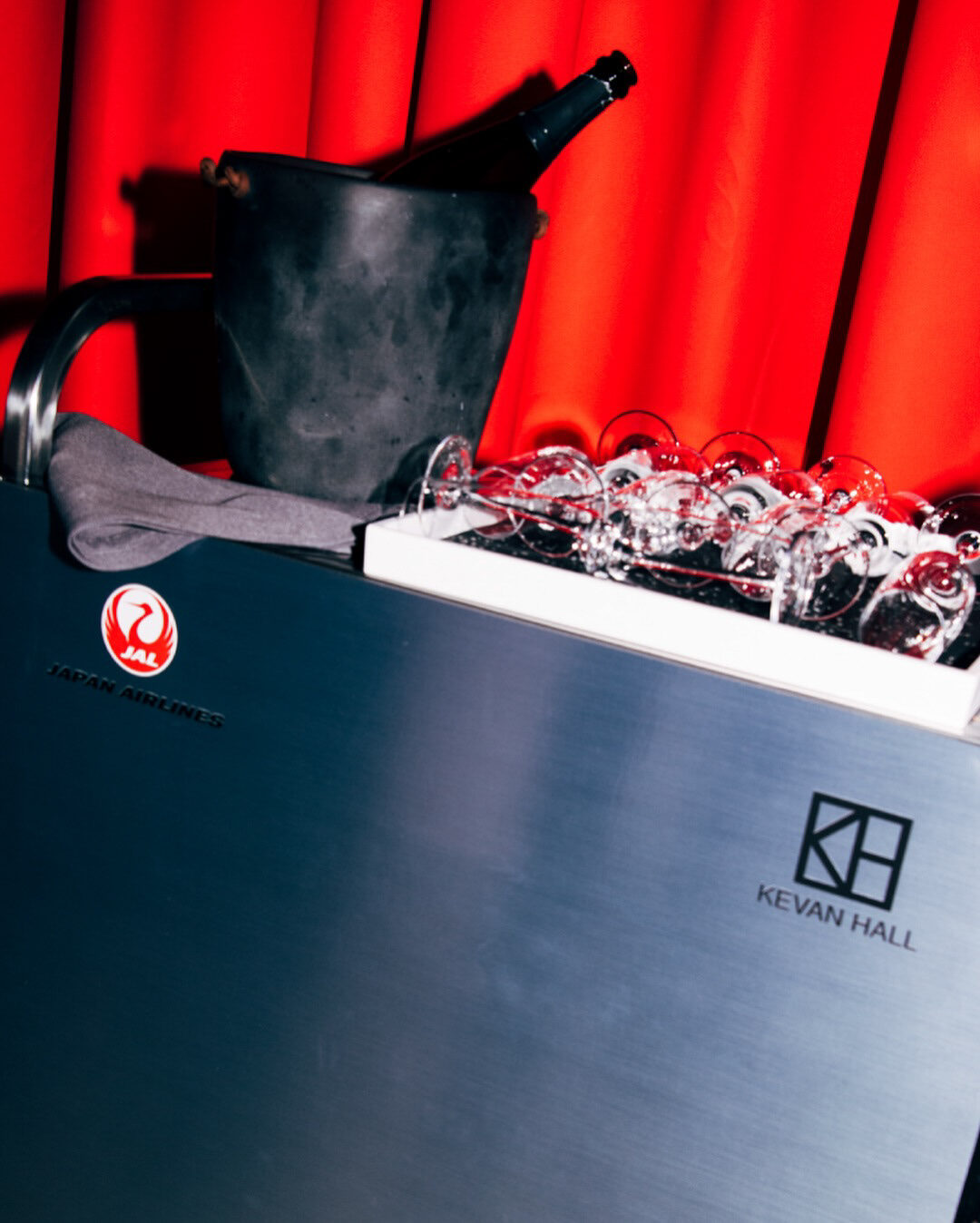 Co-branded JAL and Kevan Hall champagne service cart with red drapery
