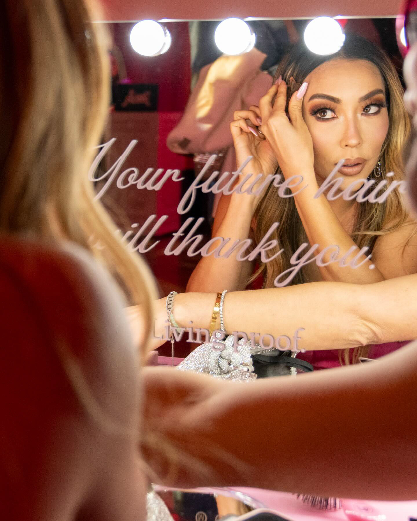Guest looking into a Living Proof mirror reading Your future hair will thank you