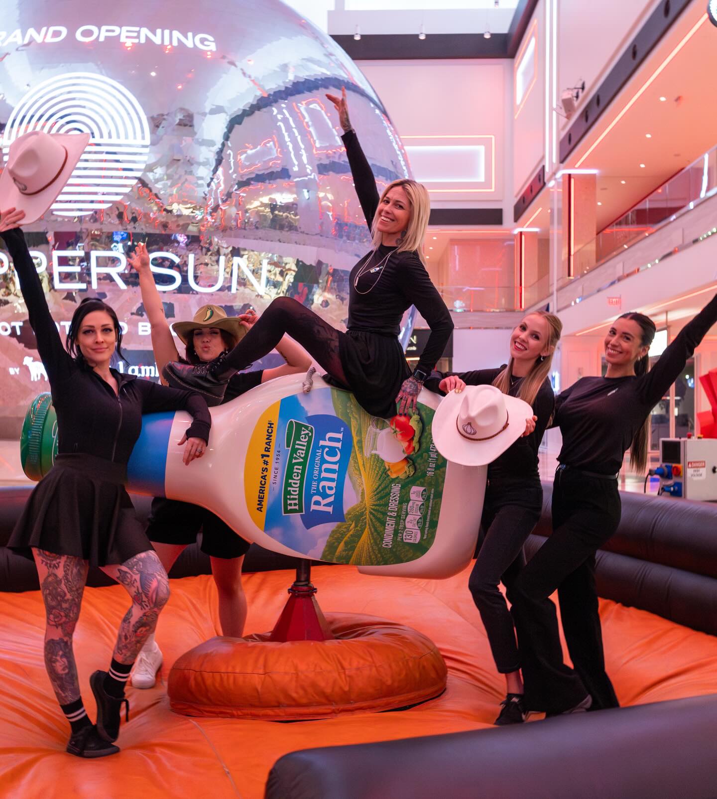 Guests posing together on the ranch bottle with flavor-themed cowboy hats