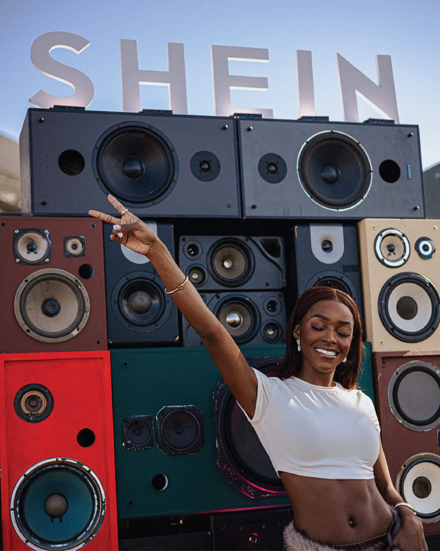 Festival guest posing in front of the SHEIN speaker wall