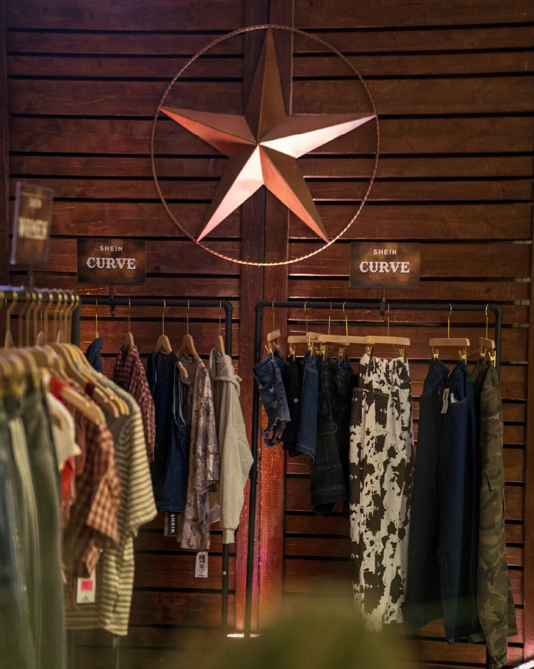 Shoppable racks beneath a Western star inside the Saloon