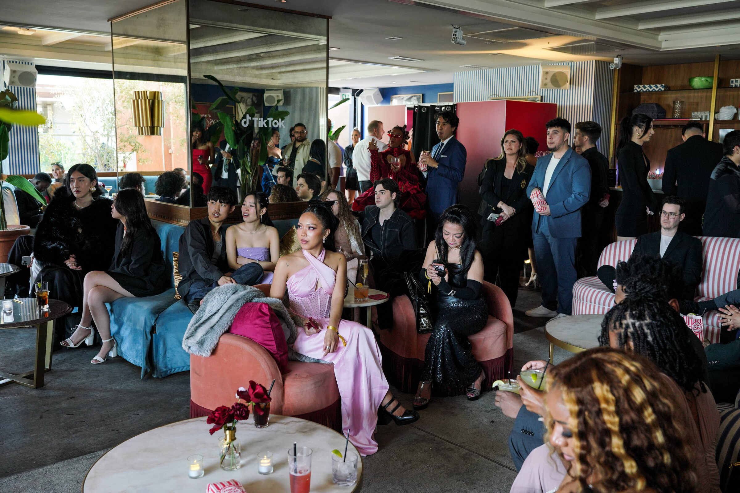 Creators watching the Oscars broadcast beneath the red velvet canopy