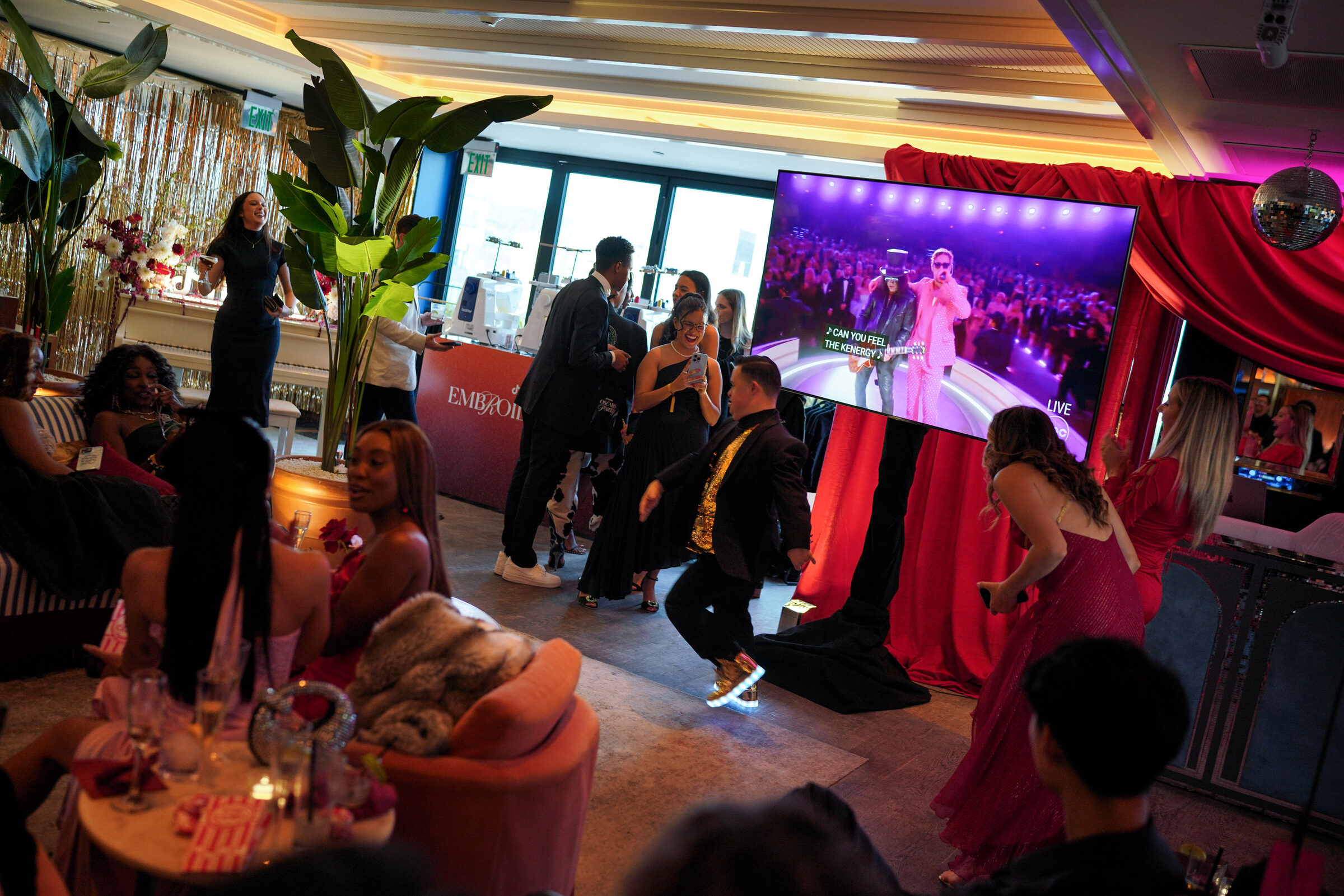 Guests dancing as a performance lights up the party screens